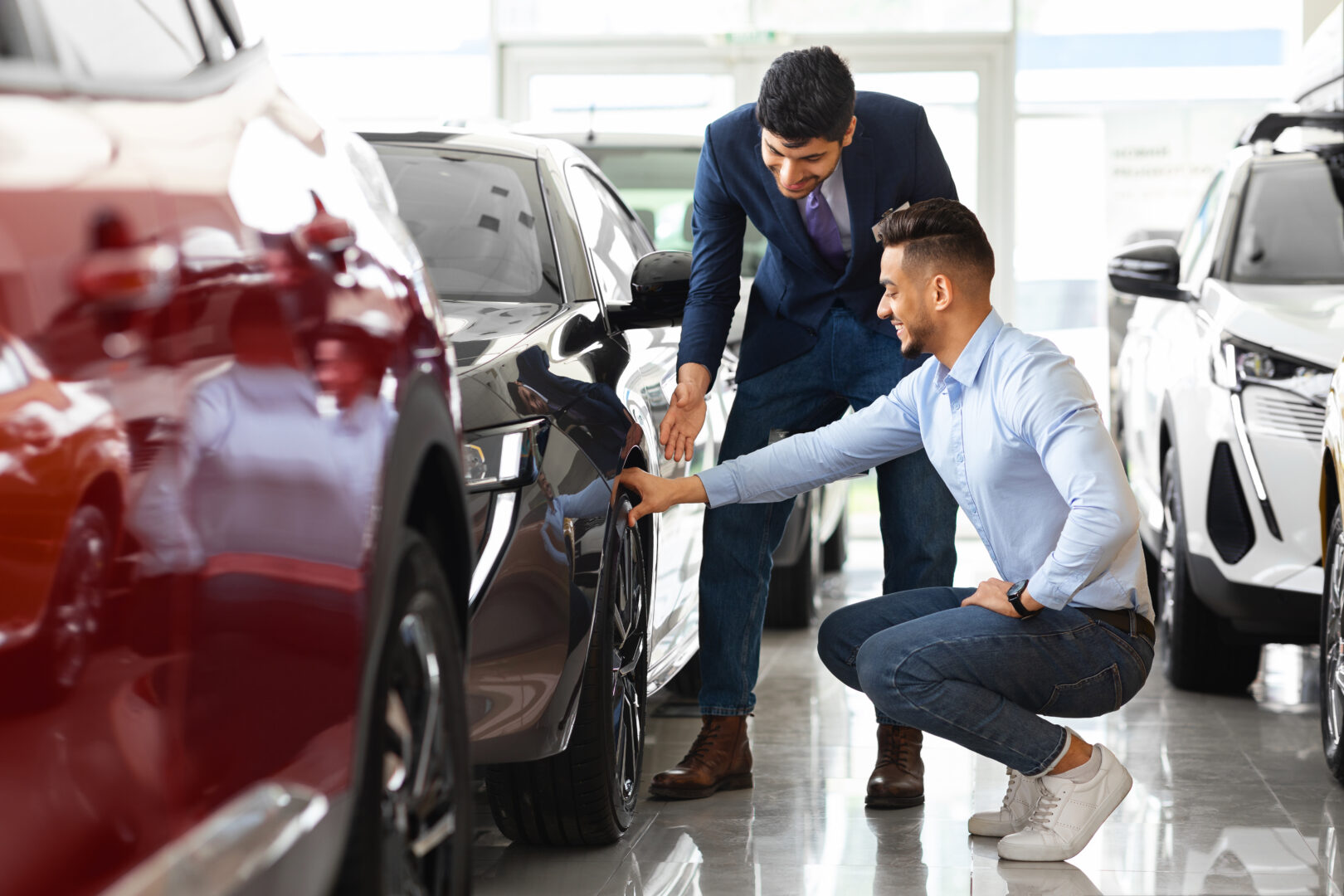 Salesman showing sports car in business development car dealership